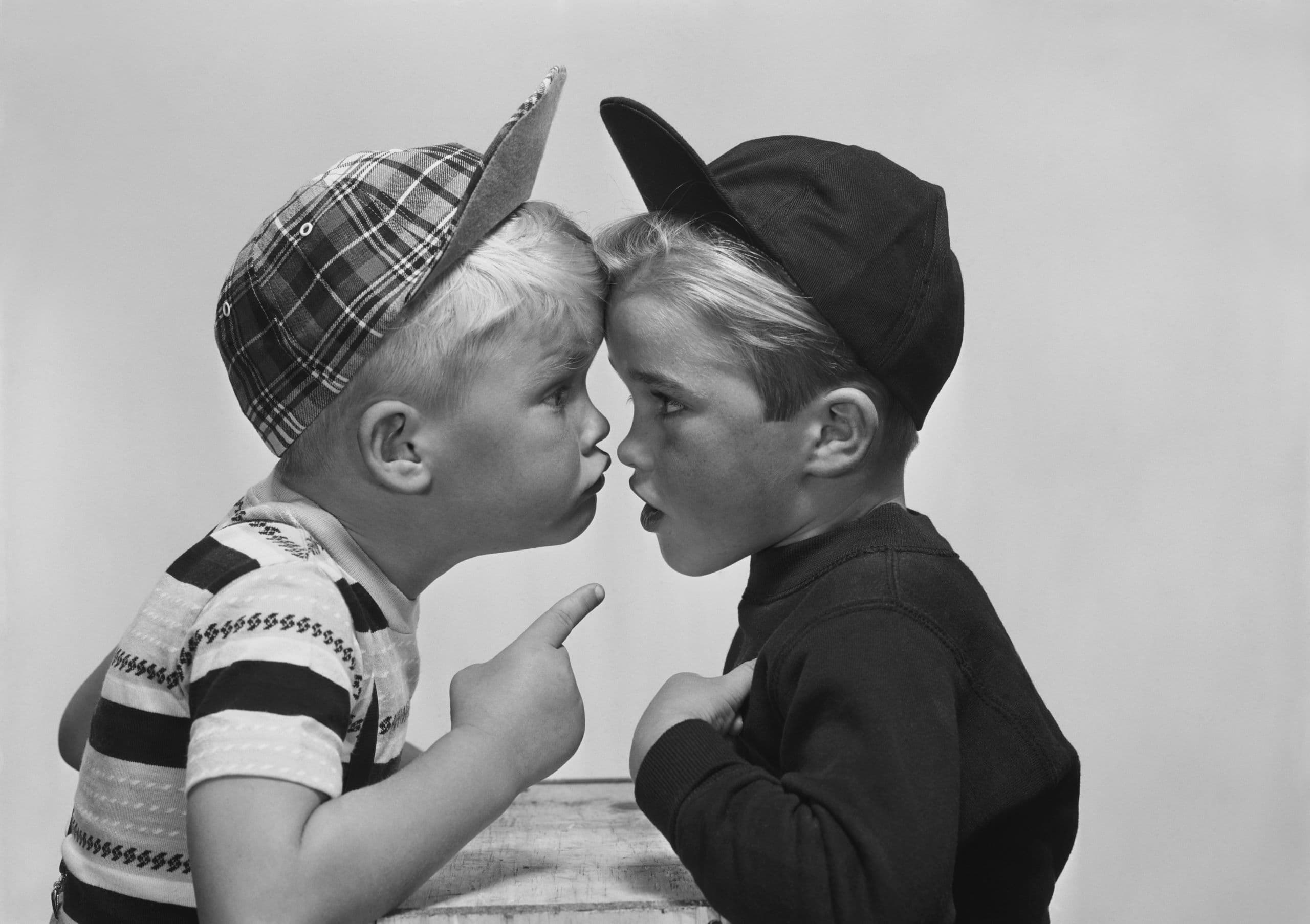 Two young boys are arguing with each other