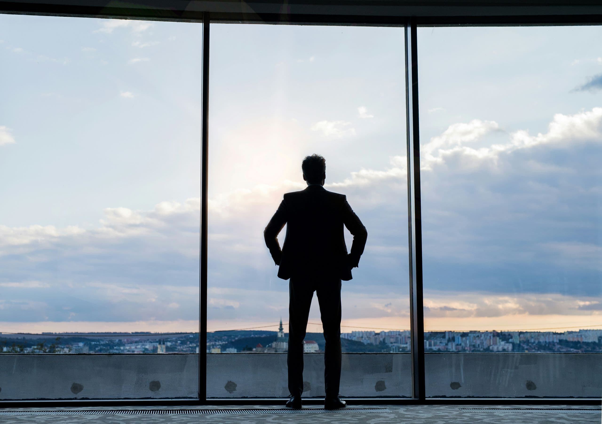 A silhouette of a man standing in front of a window