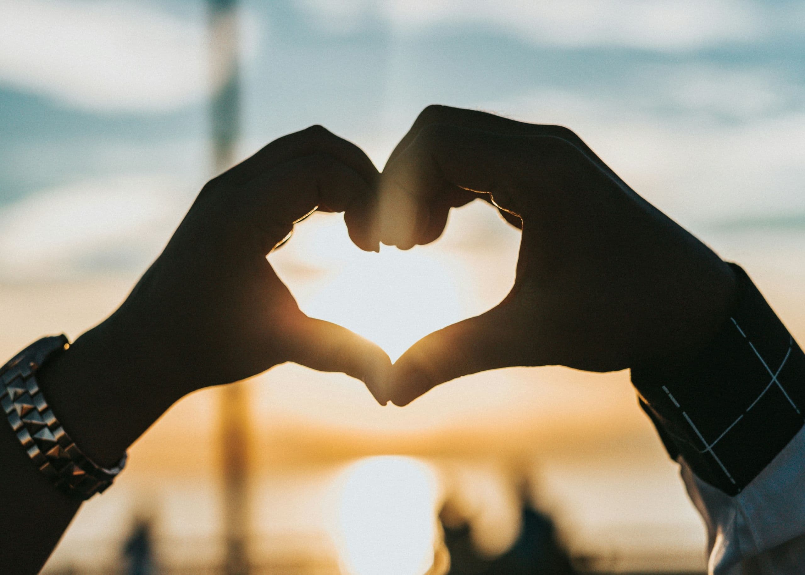 A person making a heart shape with their hands