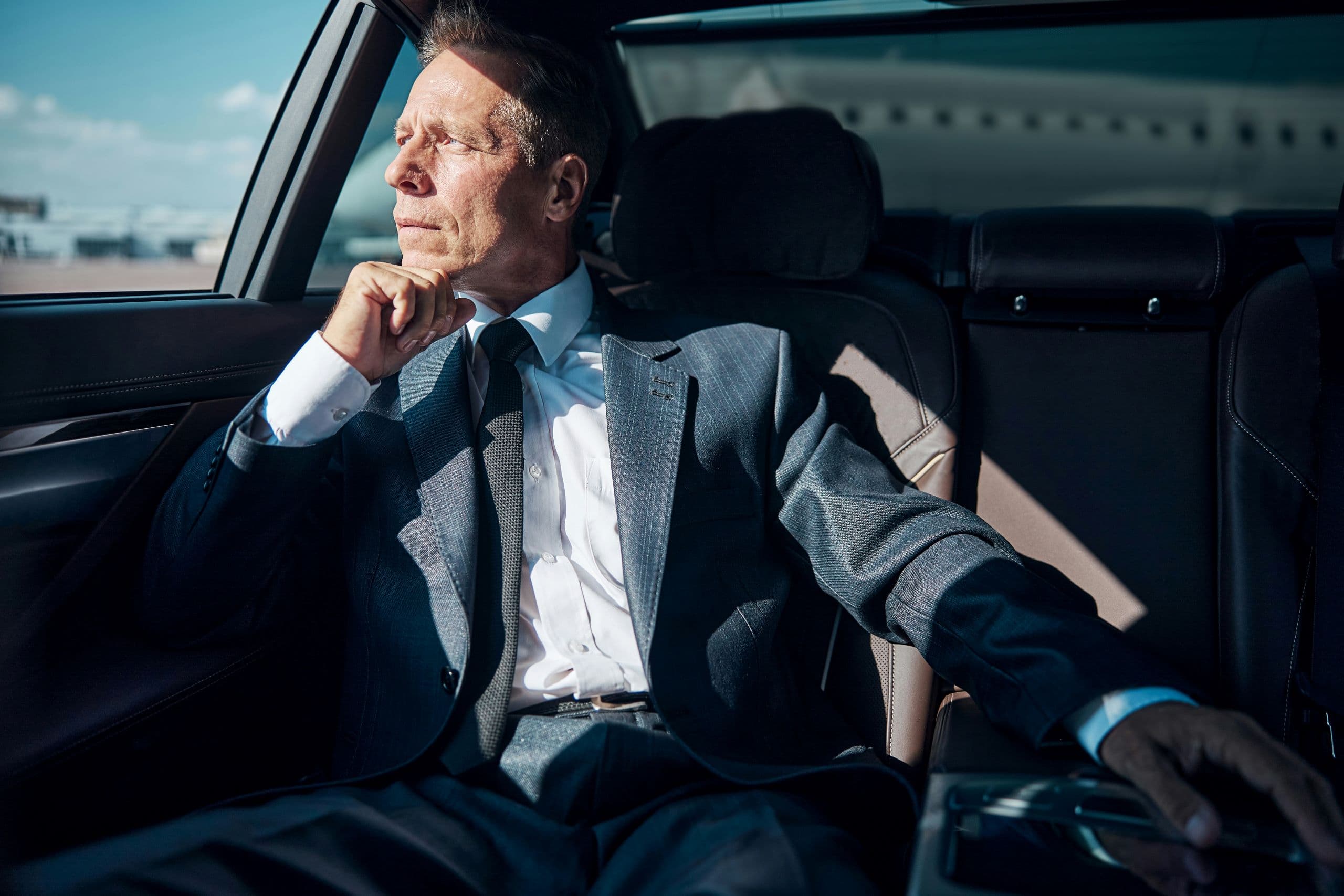 A man in a suit sitting in a car