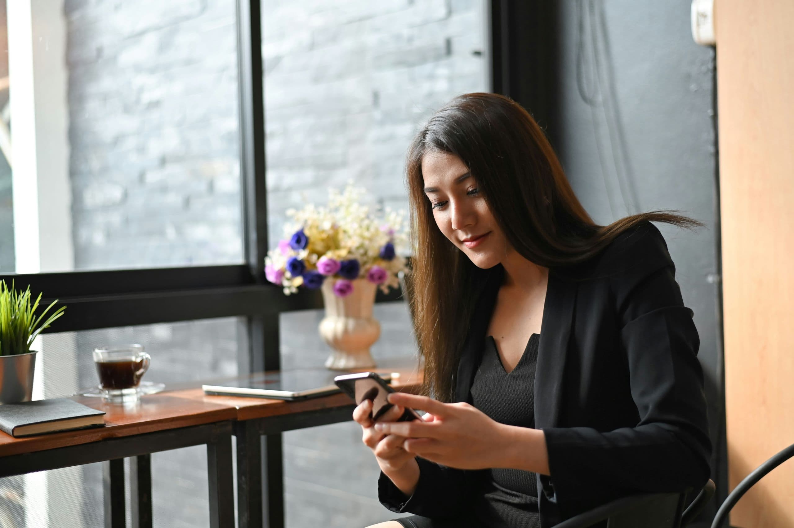 A woman sitting at a table looking at her cell phone